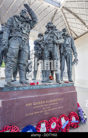 Le monument commémoratif du Bomber Command de la RAF, Green Park, Londres, Angleterre avec des statues d'aviateurs héroïques de la seconde guerre mondiale et le pavot bleu et rouge des couronnes fixées autour de la base Banque D'Images