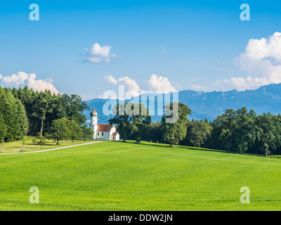 Chapelle typique sur grean prairie avec alpes et arbres en Bavière Banque D'Images