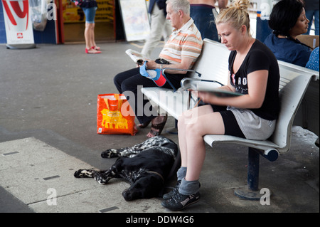 Chien endormi au pieds de womans au Richmond Gare Platform Banque D'Images