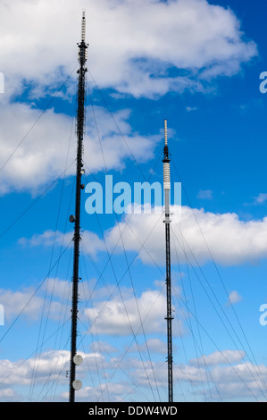 Deux mâts de télévision et de radio britannique contre un ciel bleu avec des nuages. Banque D'Images