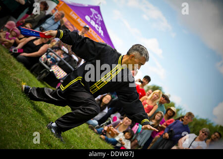 Danseur avec ventilateur papier effectuant une danse chinoise en face de foule à la Dragon Boat Festival, Cambridge, Angleterre Banque D'Images