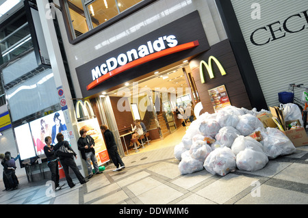 Un McDonald's restaurant fast food avec beaucoup de déchets entassés à l'extérieur. Banque D'Images
