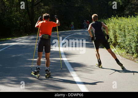 Deux jeune homme pratiquer ski à roulettes dans le parc (comme un équivalent de l'été le ski de fond). Katowice, Pologne. Banque D'Images
