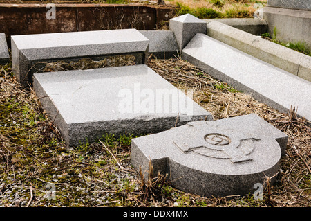 Pierre tombale brisée dans un cimetière après qu'il a été vandalisé Banque D'Images