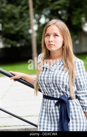 Femme en robe à carreaux avec bande bleu liée Banque D'Images