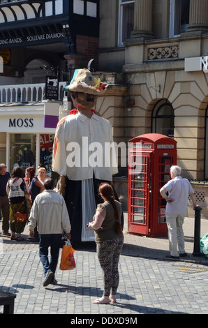 Les badauds regardant un 'giant' en centre-ville de Chester le jour du relais de la flamme olympique qui voyagent à travers la ville Banque D'Images