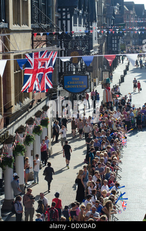 Des foules de gens qui tapissent les rues de centre-ville de Chester, en attendant le relais de la flamme olympique à arriver. Banque D'Images