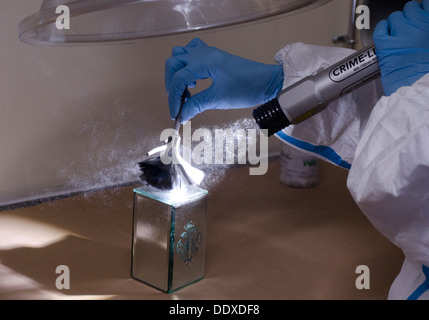Un CSI (scène de crime) un verre d'empreintes à l'aide de la brosse et de la poudre d'ornement Banque D'Images