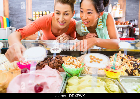 Jeune femme clients ou amis avec des sortes de glaces pour cornets et cônes et les coupes glacées dans le salon Banque D'Images