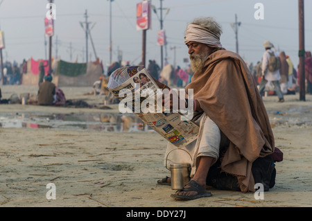 Pilgrim lisant le journal le matin, au cours de Kumbha Mela Banque D'Images