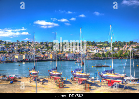 Yachts colorés dans le port de Dartmouth Devon avec coques rouges et ciel bleu vif dans HDR dans cette ville navale historique Banque D'Images