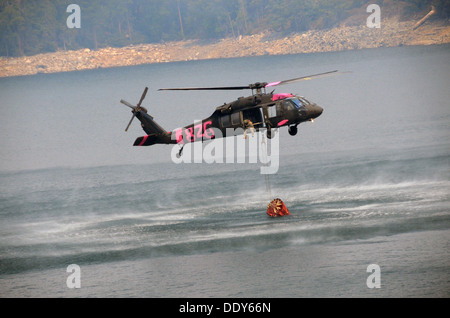 Un hélicoptère Black Hawk de l'armée américaine s'approche du barrage du lac de cerise pour remplir un seau d'hélicoptère à l'appui de la Rim Fire pendant l'incendie le 29 août 2013 près de Yosemite, CA. Banque D'Images