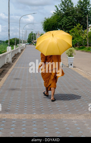 Monk walking sur la promenade avec un parapluie et une cigarette, Nong Khai, Thaïlande, Asie Banque D'Images