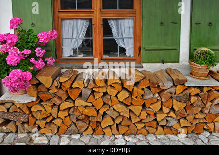 Pile de bois devant une fenêtre, Garmisch-Partenkirchen, Bavière Banque D'Images