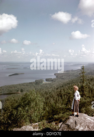 Une jeune femme en dresslooking traditionnel sur le lac Pielinen, district de Koli, Finlande, 1960. Artiste : Göran Algård Banque D'Images