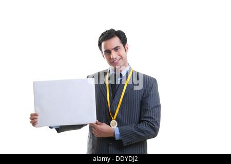 Businessman with medal holding a placard Banque D'Images