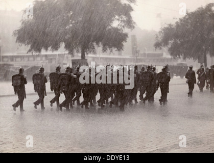 Les soldats qui reviennent à leur base dans une trombe d'eau, Stockholm, Suède, 1934. Artiste : Karl sandales Banque D'Images