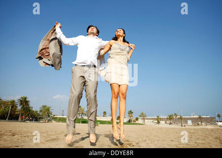 Couple jumping on the beach Banque D'Images