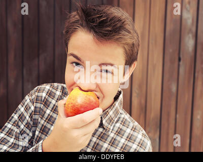 Portrait, garçon, adolescent de mordre une pomme Banque D'Images