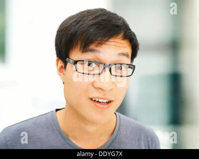 Jeune homme, Asiatique, étudiant à lunettes, souriant, surpris Banque D'Images