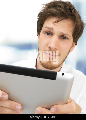 Portrait of a businessman holding un iPad, sérieux, a souligné, anxieux, d'avoir des problèmes, crise, au bureau Banque D'Images