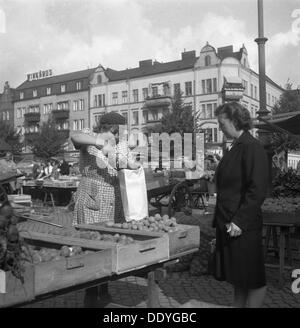 Femme l'achat de pommes de terre d'une stalle de fruits et légumes sur le marché, Malmö, Suède, 1947. Artiste : Otto Ohm Banque D'Images