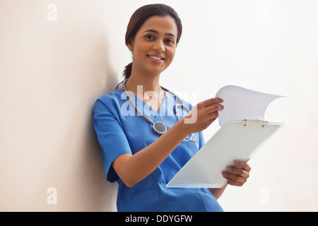 Portrait of happy young doctor avec clip board against white background Banque D'Images