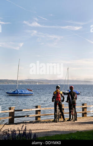 Couple on mountain bikes par le lac, le lac Ammer, Schondorf, Bavière Banque D'Images