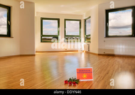Panneau de bienvenue et de roses sur le sol, grand salon avec fenêtres et lumière parquet, de composition, de location vacances Banque D'Images