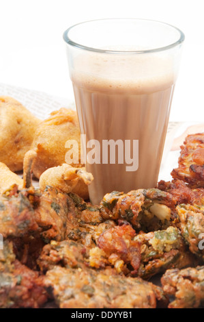 Verre de chai avec pakoras , bhajiyas et boules de pommes de terre frites isolated over white background Banque D'Images