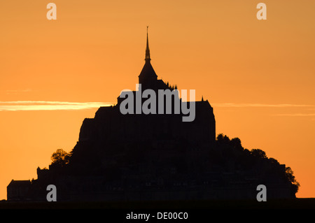 Mont Saint-Michel (Saint Michael's Mount) silhouetté par le coucher du soleil, vu à travers la campagne environnante, Aquitaine (Basse-Normandie), France Banque D'Images