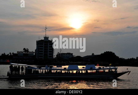 Vue du coucher de soleil d'un bateau à longue queue d'ossature croisière le long de la rivière Chao Phraya, Bangkok Banque D'Images