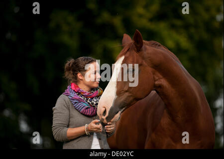 Femme debout à côté d'un cheval de Hanovre Banque D'Images