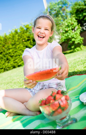 Fille de manger un morceau de pastèque dans le jardin Banque D'Images