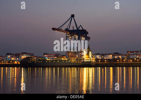 Porte-conteneur est chargé au crépuscule, Terminal à conteneurs Altenwerder, port de Hambourg, Hambourg Banque D'Images