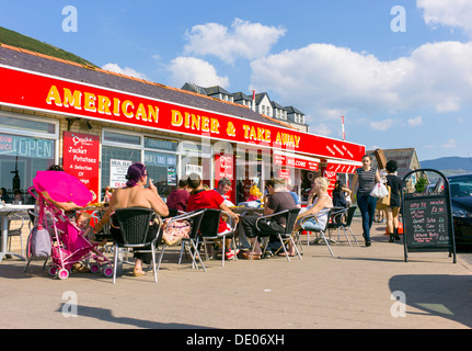 Un restaurant de style américain et l'emporter avec des vacances visiteurs assis à l'extérieur des tables, occupé à l'heure d'été colorés scene Banque D'Images