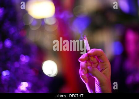 Berlin, Allemagne. Le 05 août, 2013. Une femme tient une cigarette dans sa main à l'événement 'Music répond aux médias' dans Grand Hotel Esplanade à Berlin, Allemagne, 05 septembre 2013. Photo : Jens Kalaene/dpa/Alamy Live News Banque D'Images