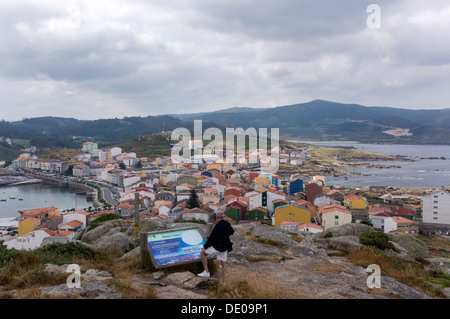 Un touriste contemple une vue de la ville de Muxia à partir de l'une des collines près de la ville. Banque D'Images