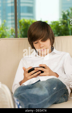 Teenage boy using cell phone Banque D'Images