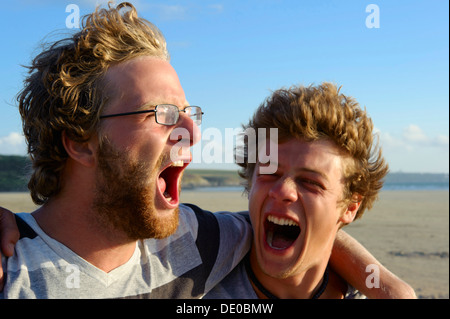 Deux jeunes hommes criant et enlacés, Bretagne, France, Europe Banque D'Images