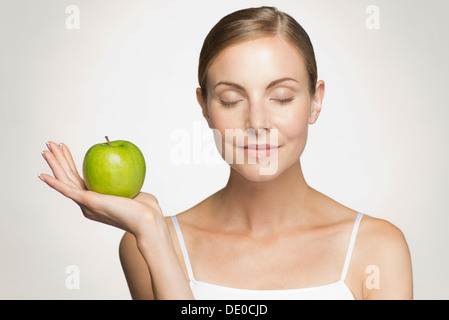 Young woman holding green apple Banque D'Images