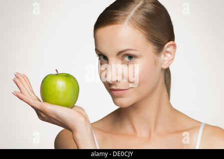 Young woman holding green apple Banque D'Images