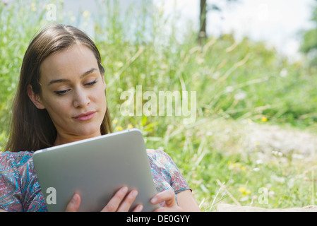 Woman using digital tablet outdoors Banque D'Images