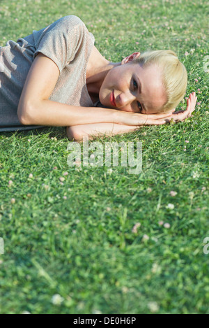 Young woman lying on grass, portrait Banque D'Images