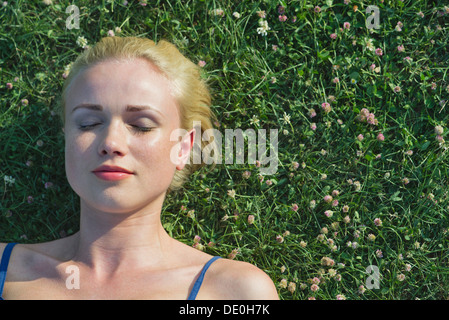 Jeune femme sieste sur l'herbe, portrait Banque D'Images