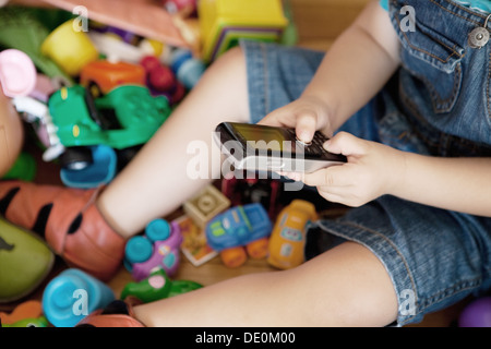 Enfant jouant avec cell phone, cropped Banque D'Images