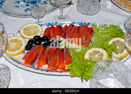 Plat de poisson rouge sur les feuilles de salade avec du citron. Banque D'Images