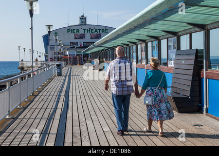 L'Angleterre, Bournemouth, Bournemouth, Dorset, Elderly Couple Walking on Pier Banque D'Images