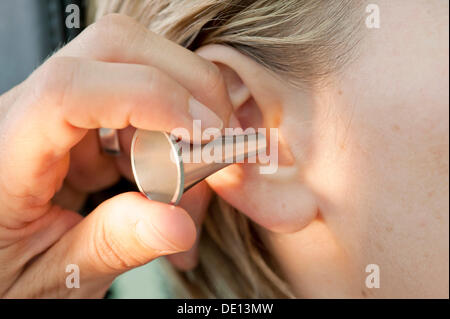 Otorhinolaryngologiste examinant une fille avec un spéculum d'oreille Banque D'Images