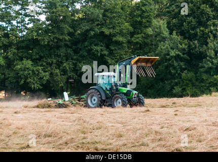 Pour sécher le foin tournant agriculteur, Dreicheich-Goetzenhain, Hesse Banque D'Images